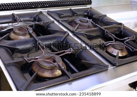 four large gas stove in an industrial kitchen in the school canteen