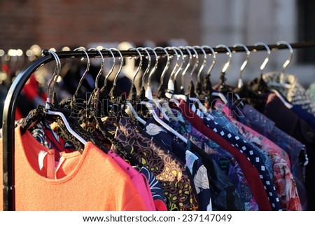 Many vintage style clothes  for sale at an outdoor flea market