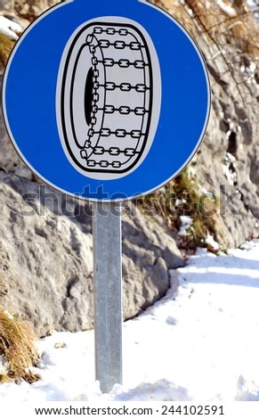 road sign with compulsory snow chains aboard the car in winter