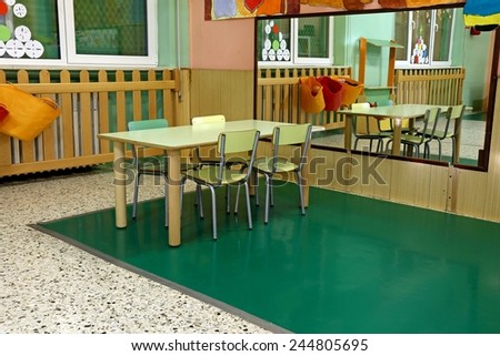 table and chairs in the wide room of the nursery with a large mirror on the wall
