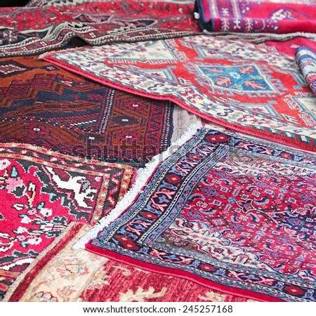 many Asian rugs for sale in the shop of fabrics and textiles