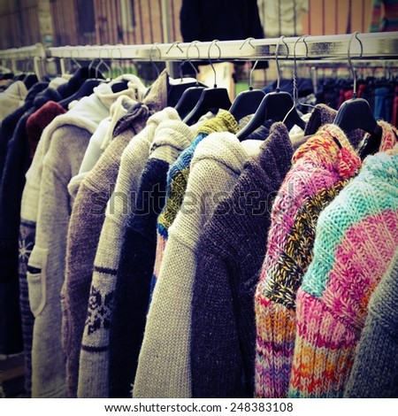 sweaters and vintage clothes in open-air flea market