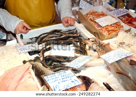 fishmonger sells the fresh fish at the fish market in Italy