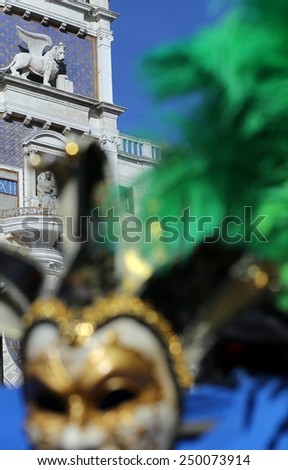 clocktower with winged lion and a venetian mask in venice Italy