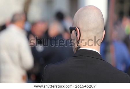 bald security guard with the headset to control people