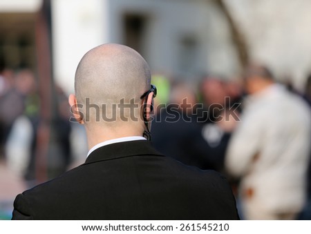 security guard with dark glasses and a radio headset to control people