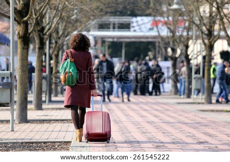 smart career woman during a business trip with the trolley in public park