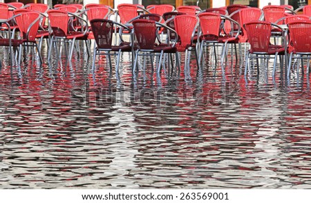 Venice, red chairs during high tide in winter