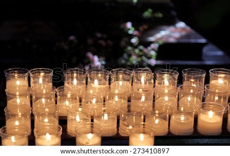 many lit candles to pray inside a church