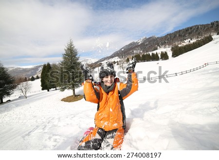 cute boy play with snow in the mountains in winter