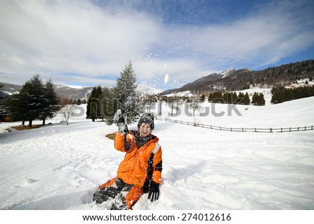 cute little boy play with snow in the mountains in winter