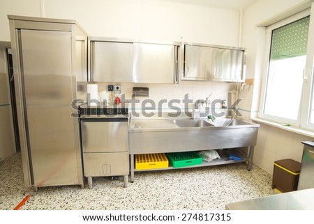 large industrial kitchen with refrigerator, dishwasher and sink all stainless steel