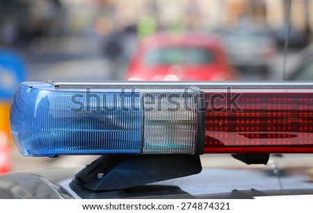 Blue and red flashing sirens of police car during the roadblock in the city