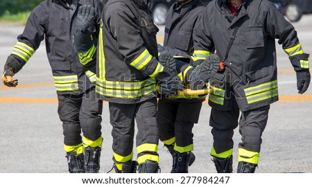 Four brave Firefighters carry a firefighter with the medical stretcher