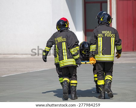Four brave Firefighters carry a fellow firefighter with the medical stretcher