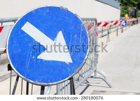 big road signal with arrow on the excavation during the roadworks for the laying of fiber optical