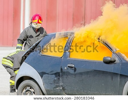 practice of firefighters in the Firehouse and simulation of traffic accident and orange smoke from the broken car