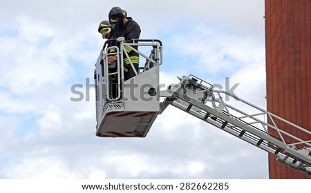 firefighters in the fire truck basket during the practice of training in fire station