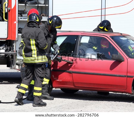 Firefighter opens car door with pneumatic shears after the traffic accident