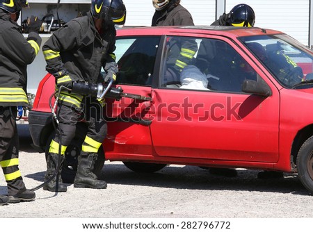 Firefighter opens car door with pneumatic shears after the traffic accident