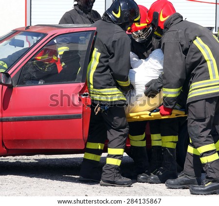 italian firemen in action and pull the injured from the car after the accident