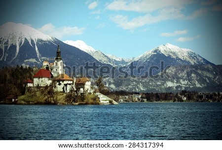 Church on the island of Lake BLED in SLOVENIA and the snowy mountains