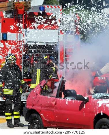 Firefighters put out the fire with white foam in the car
