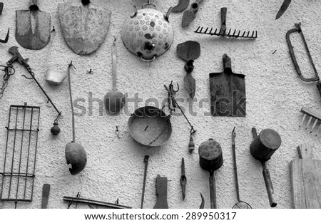 many ancient farming tools hanging on the wall of the rural House