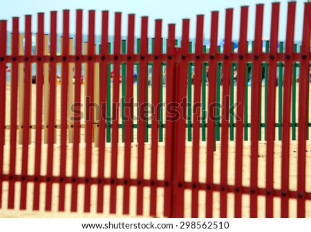 colorful fence of a playground on the beach in summer by the sea