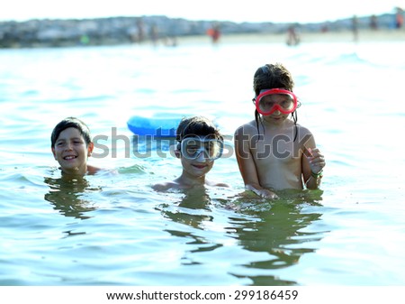 three young brothers have fun playing in the sea in summer