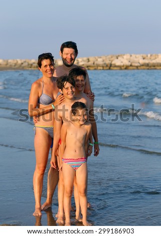 family of five people during the summer holidays on the beach