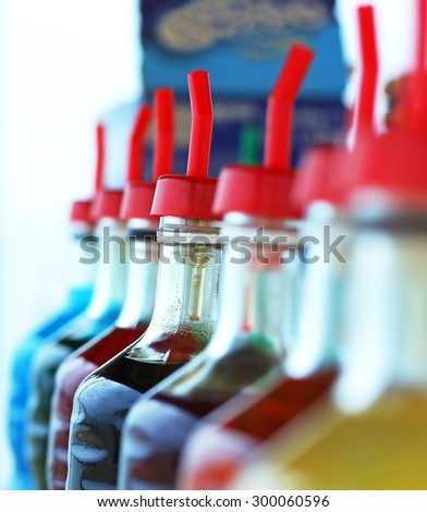 many bottles of colored syrup for preparing ice creams in summer