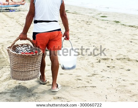 seller on the beach with fruit skewers made with coconut and strawberries