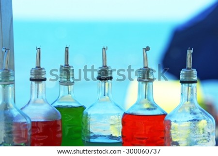 many bottles of syrup for preparing ice creams in summer on the beach