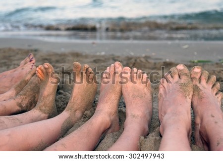 ten feet of a family barefoot by the sea on the beach in summer