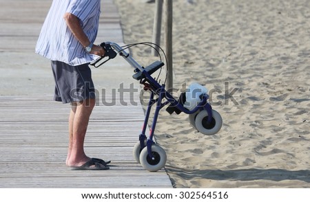 old walking with Walker on the beach in summer