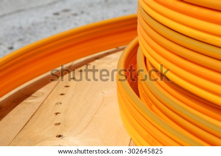 long coils of orange plastic pipes for the installation of underground utilities and energy of optical fibers