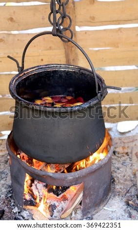 black  cauldron with fruits to cook the tasty mulled wine in the country festival in europe