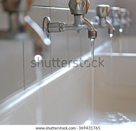 stainless steel taps with water coming out of the school in the sink