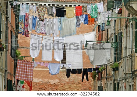 street in venice with washing hung out to dry in the sun over the water channel