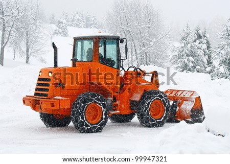 orange snow plows to work clearing the snow