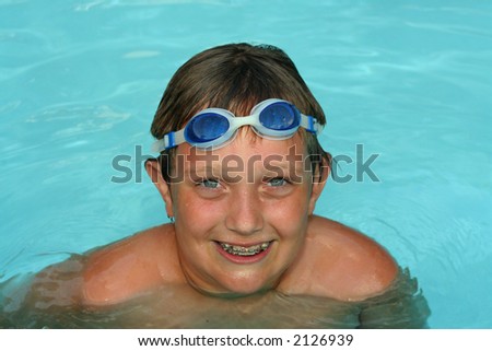 Boy with braces smiling in a swimming pool