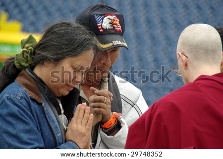 FOXBORO, MA - MAY 3: Buddhists pray with a Buddhist Monk at Gillette Stadium during the visit of His Holiness the 14th Dalai Lama on May 3, 2009 in Foxboro, MA