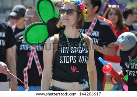 MINNEAPOLIS - JUNE 30: An unidentified woman marches, in the TC Gay Pride Parade, to raise awareness of the impact of HIV stigma has on people living  with HIV and AIDS, on June 30, 2013, in Mpls.
