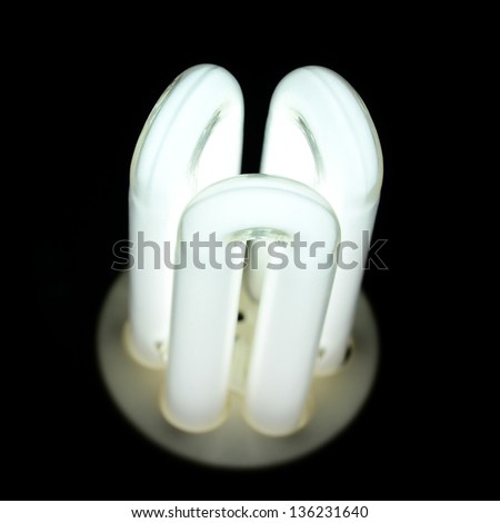 Glowing fluorescent light bulb isolated on a black background.