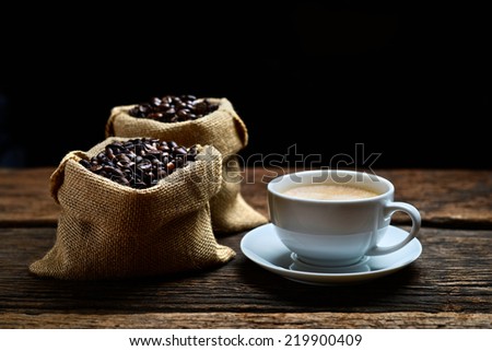Coffee cup with coffee beans on burlap bag