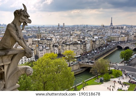 Notre Dame of Paris: Famous Chimera (demon) overlooking the Eiffel Tower at a spring day, France