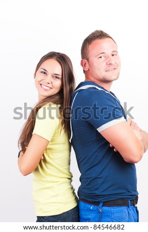 Portrait of a happy young couple standing back to back