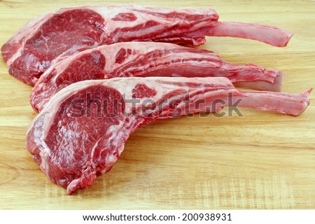 Closeup photo of fresh Lamb chops on a wooden cutting board