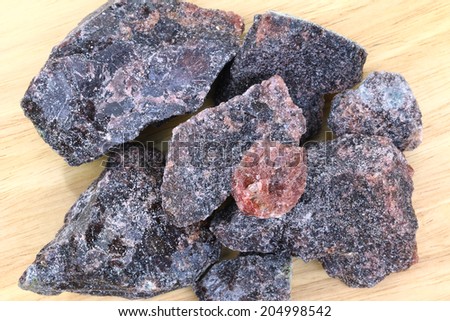 Big rock salts - Black Indian Salt crystals (Himalayan Pink Salt) on a wooden background